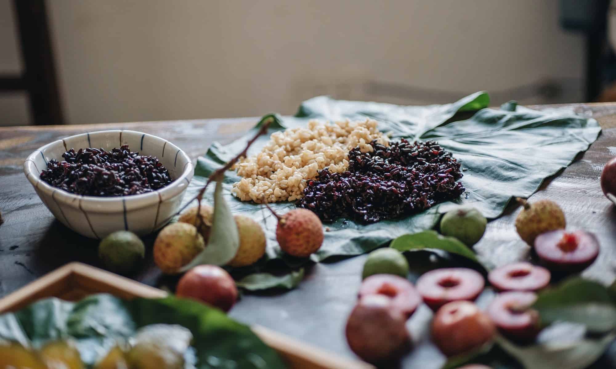 Hình ảnh minh họa các tác động và so sánh giữa các góc nhìn phân tích: một bàn lễ Tết Đoan Ngọ với cơm rượu bên cạnh biểu đồ lợi ích sức khỏe (tiêu hóa, da), phía sau là hình ảnh gia đình Việt Nam quây quần và chợ bán cơm rượu