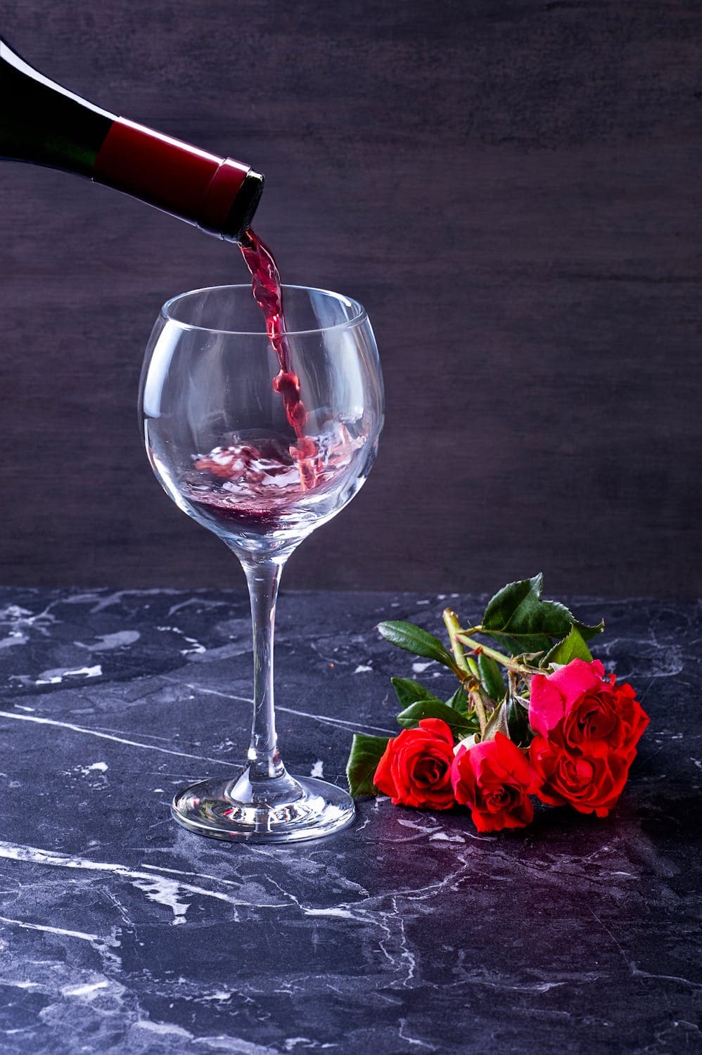 Một bàn tiệc với ly rượu vang đỏ, món ăn truyền thống Việt Nam và phương Tây, thể hiện sự giao thoa văn hóa trong cách thưởng thức rượu vang.