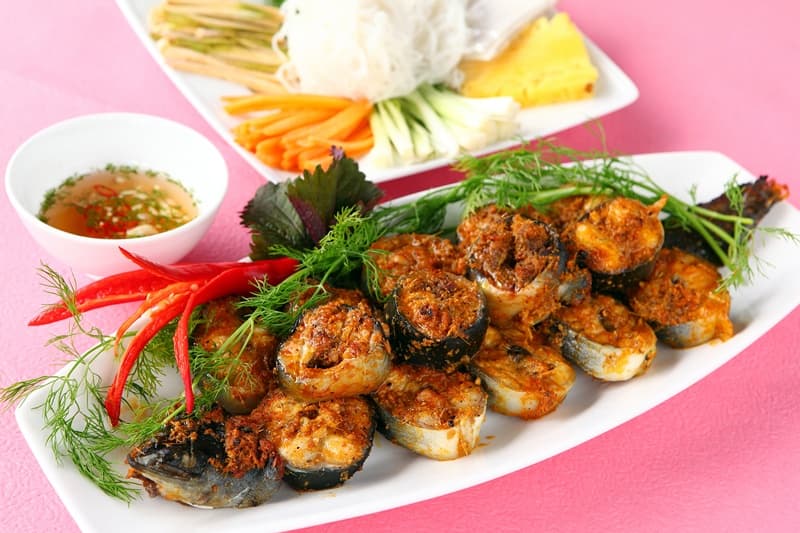 Hình ảnh biểu đồ so sánh giá trị dinh dưỡng của cá chình với cá hồi và cá thu, kèm theo hình minh họa món cá chình kho nghệ.